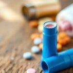 Astma-inhalatorer og medisiner på en treoverflate.