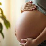 Gravid kvinne holder magen i et rolig miljø.